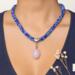 Blue Kumihimo necklace worn on model, rose quartz pendant centered, handmade beaded jewelry for everyday wear